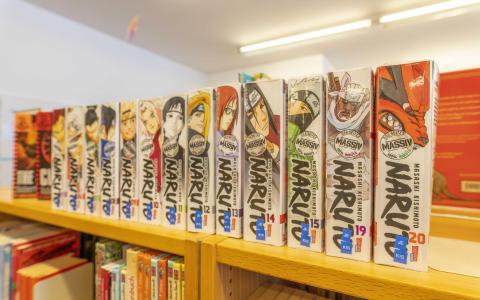 Man sieht eine Reihe Mangas "Naruto" im Regal